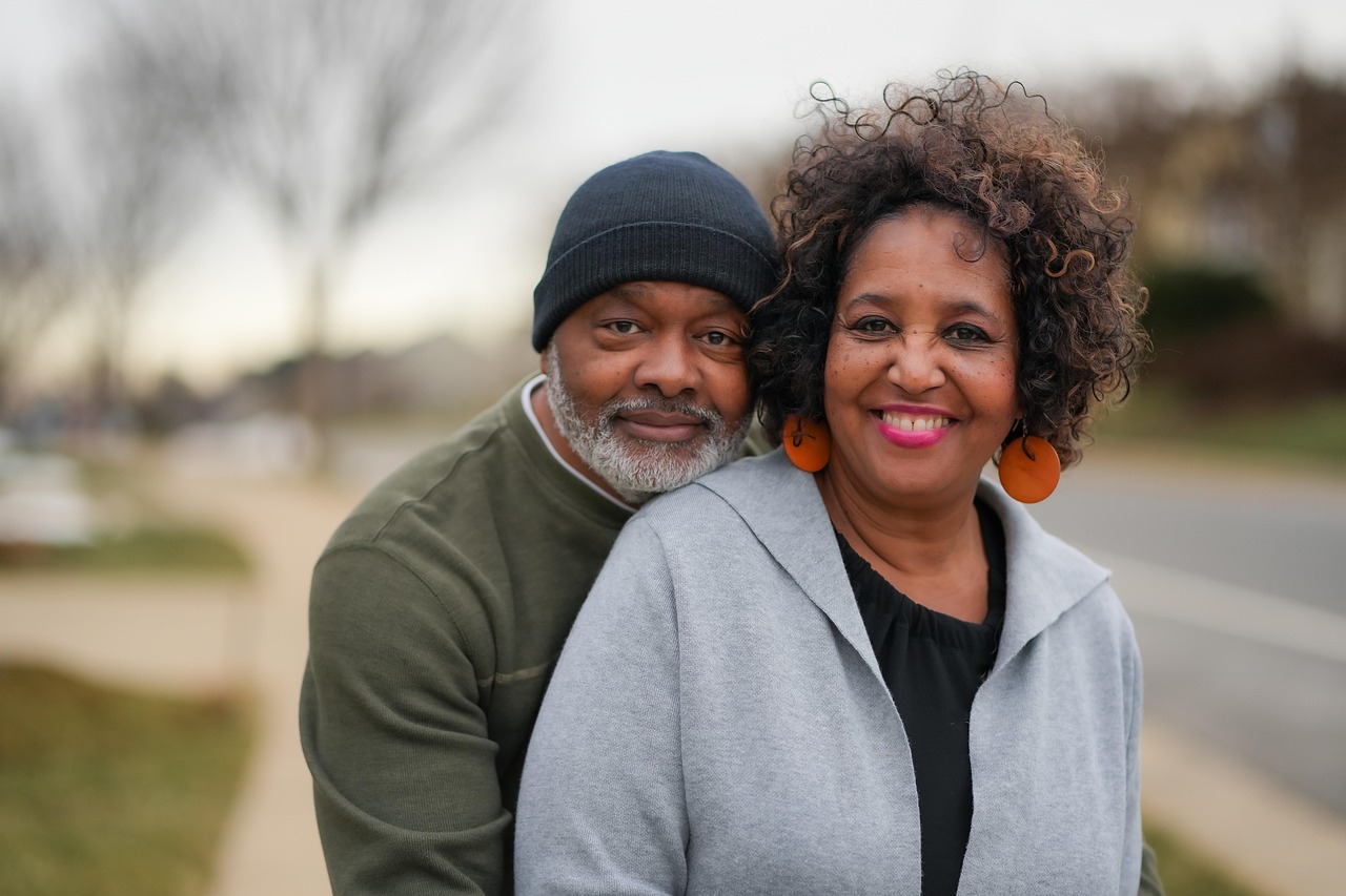Loving elderly couple holding hands during their joint legacy interview